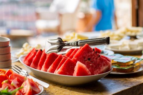 Eine Schüssel Wassermelone auf einem Tisch mit Tellern voller Essen in der Unterkunft kayadibi cave hotel in Ürgüp