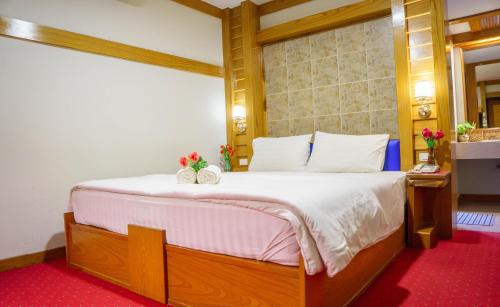 a bedroom with a large bed with two pumpkins on it at โรงแรมศิริโฮเต็ล Sirihotel Korat in Nakhon Ratchasima