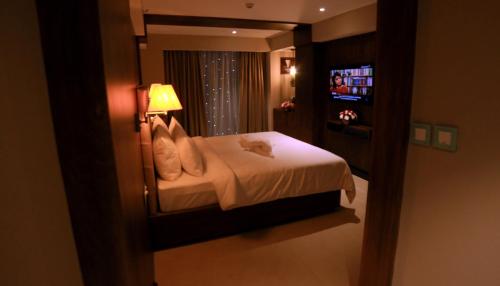 a bedroom with a bed with a cat sitting on it at YASH INTERNATIONAL in Kozhikode