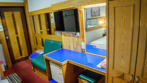 a small room with a blue desk and a bedroom at โรงแรมศิริโฮเต็ล Sirihotel Korat in Nakhon Ratchasima