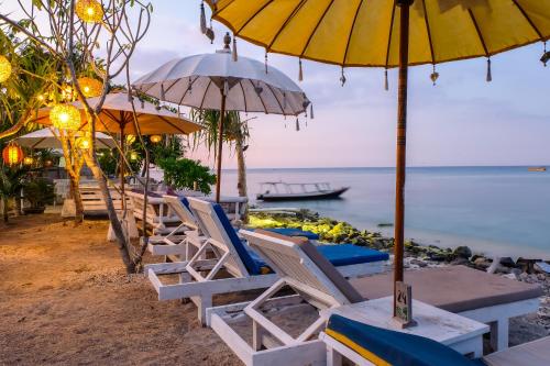 a group of chairs and umbrellas on a beach at Sedjiwa in Gili Islands