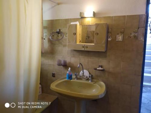 a bathroom with a sink and a mirror at MARITSA COUNTRY HOME in Fternón