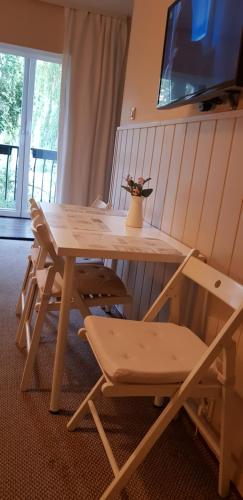 drewniany stół z krzesłem i wazon z kwiatami w obiekcie Sopot kawalerka 200m od morza w mieście Sopot