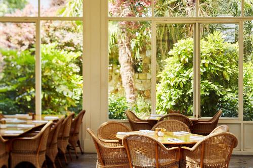 a dining room with tables and chairs and windows at Chateau Yering in Yarra Glen