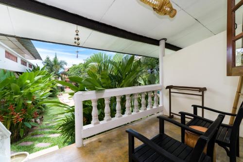 eine Veranda mit 2 Stühlen und einen Balkon mit Pflanzen in der Unterkunft Visit Natural Detox Resort in Lamai