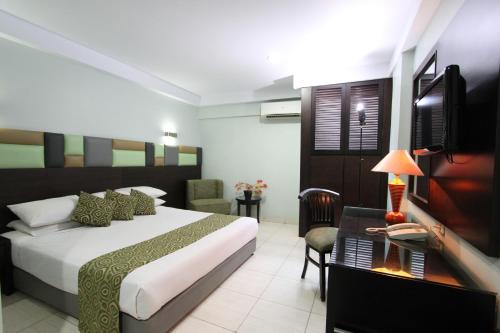 a hotel room with a bed and a desk at Hotel Alma in Jakarta