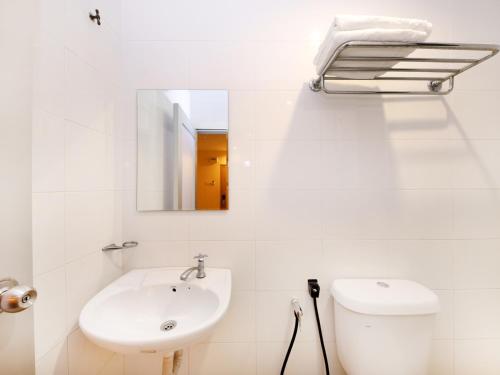 Baño blanco con lavabo y espejo en Super OYO 635 Seven Days Hotel en Raub
