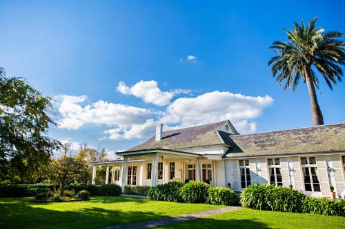 an old white house with a palm tree at Chateau Yering in Yarra Glen