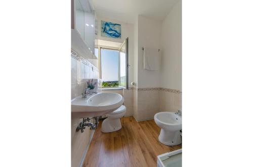 ラヴァーニャにあるVillarosa Apartmentのバスルーム(洗面台、トイレ、鏡付)