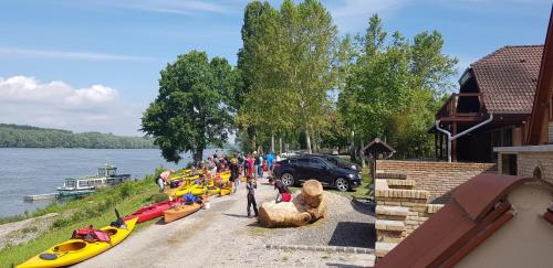 a group of people standing next to a river with boats at Duna Dráva Vendégház in Érsekcsanád