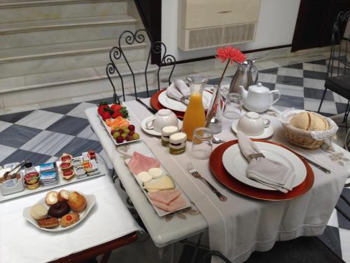 a table with plates of food on it at Hostal Palacio San Bartolomé in El Puerto de Santa María