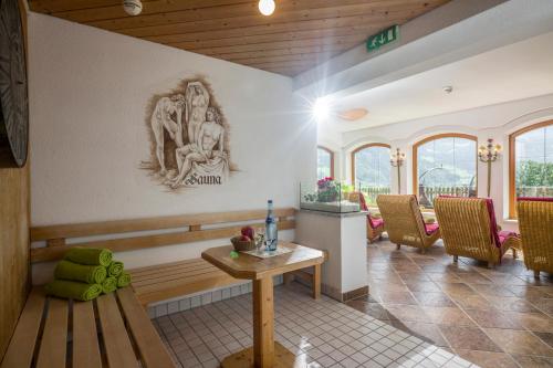a room with a table and a statue on the wall at Hotel Pension Wiesenhof in Kaltenbach