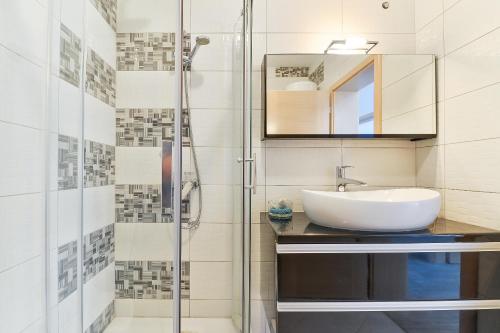a bathroom with a sink and a shower at Crowonder Luxury Vir- 6 New Apartments for Families with Playground for Kids in Vir