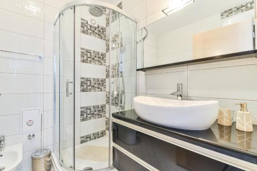 a bathroom with a sink and a glass shower at Crowonder Luxury Vir- 6 New Apartments for Families with Playground for Kids in Vir