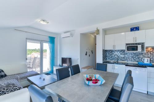 a kitchen and a table with a bowl of fruit on it at Crowonder Luxury Vir- 6 New Apartments for Families with Playground for Kids in Vir