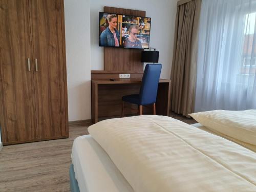 een hotelkamer met een bed en een bureau met een tv bij Nordseehotel Apartments in Wilhelmshaven
