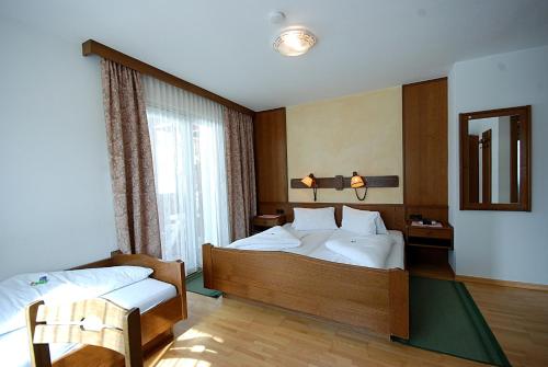 a hotel room with a bed and a window at Wastingerhof in Obertilliach