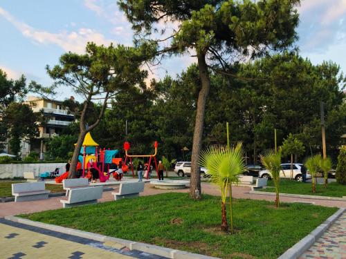 un parque con parque infantil con sillas y zona de juegos en Apartment near the sea 1, en Kobuleti