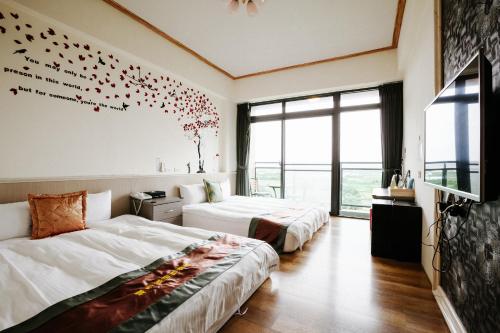 a hotel room with two beds and a tv at Lisinty Resort in Hengchun