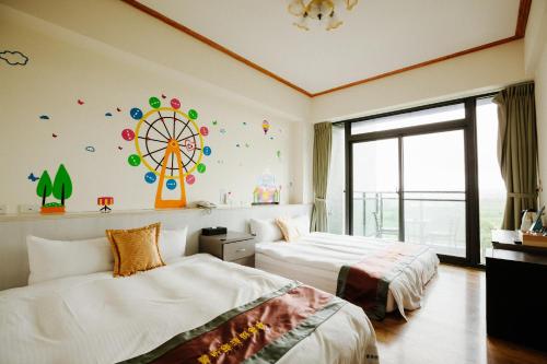 a bedroom with two beds and a ferris wheel on the wall at Lisinty Resort in Hengchun