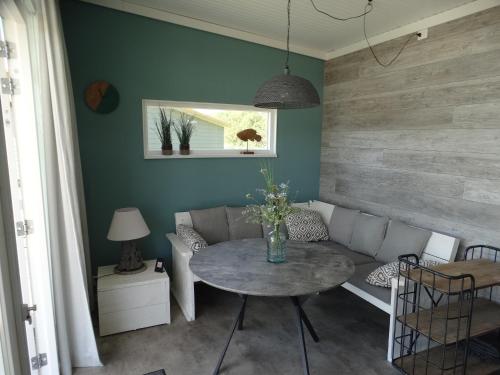 a living room with a table and a couch at Beach Lodges Oostvoorne in Oostvoorne
