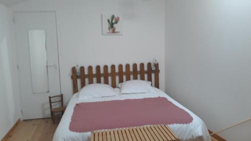 1 dormitorio con 1 cama grande y cabecero de madera en Pigeonnier Brens, en Brens