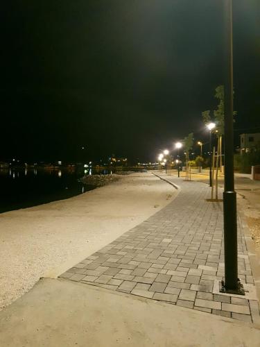a street at night with lights on a sidewalk at Apartments Anka in Vinišće