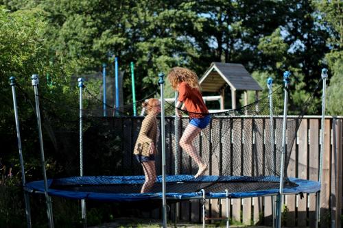 two young girls jumping on a trampoline at Villa M in Simrishamn