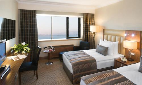 a hotel room with a bed and a desk at Mövenpick Hotel Izmir in Izmir