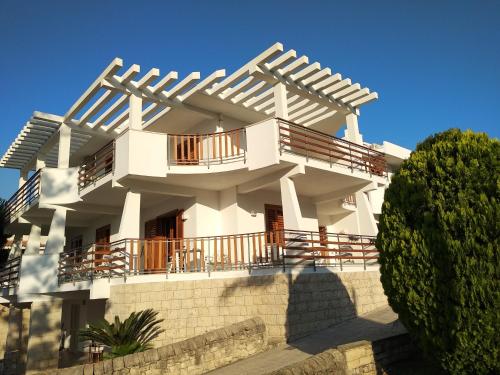 a white building with a balcony on top of it at VILLA VEGA in Fontane Bianche