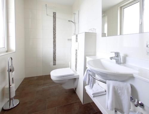 La salle de bains blanche est pourvue de toilettes et d'un lavabo. dans l'établissement Braugasthof Schmidt`s Rabenbräu, à Neustift an der Lafnitz
