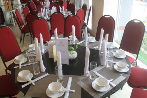 a table in a room with red chairs and a table with plates and chop sticks at Chau Pho Hotel in Chau Doc