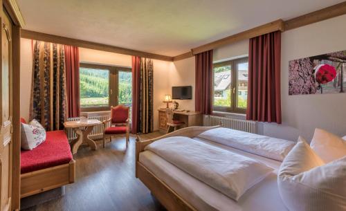 a bedroom with a large bed and a red chair at Landgasthof Jostalstüble in Titisee-Neustadt