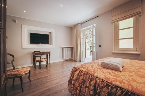 a bedroom with a bed and a table and a television at Residenza San Vito in Calamandrana