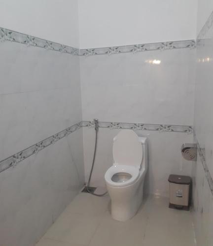 a bathroom with a toilet in a white room at Khách Sạn Ngọc Hân in Tinh Bien