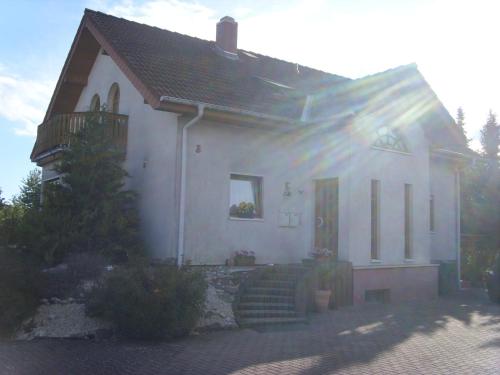 Cette petite maison blanche dispose d'une terrasse couverte et d'escaliers. dans l'établissement Ferienwohnung Ina, à Rust