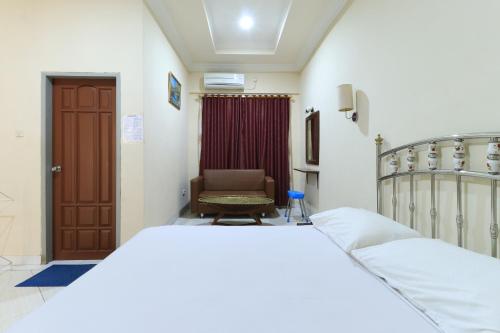 una camera con letto e sedia di Andrin Daspatt Hotel a Makassar