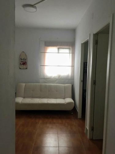 a white couch in a room with a window at Estudios Eucalyptal El Palmar a 100 m del mar in El Palmar