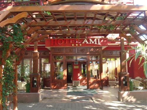 an entrance to a hotel with a wooden pergola at Hotel Ami in Baile Felix