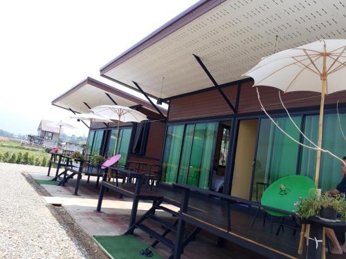 a row of tables and umbrellas on a building at บวกบัววิวรีสอทร์ in Nan