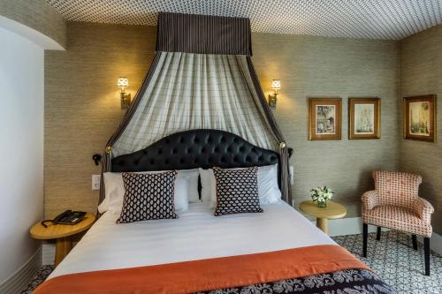 a bedroom with a large bed and a chair at The First One Madrid Preciados in Madrid