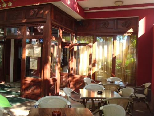 a dining room with tables and white chairs at Hotel Ami in Baile Felix