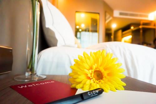 a yellow flower sitting on a table with a pen at GLOW Sukhumvit 5 in Bangkok