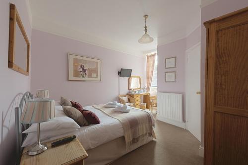 a bedroom with a bed and a table with a lamp at Cliftons Guest House in Truro