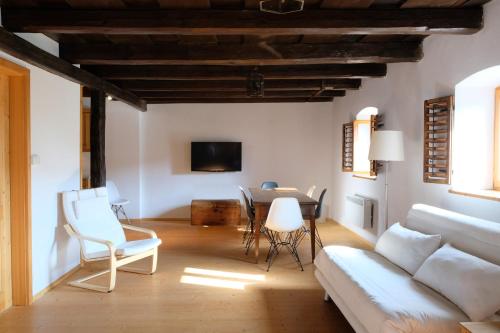 a living room with a couch and a table and chairs at Weinkellerurlaub Röschitz in Roggendorf