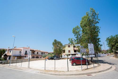 a red car is parked in a parking lot at Residence Cala Viola in Cala Liberotto