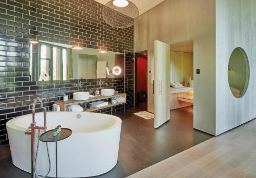 un ampio bagno con vasca e lavandino di Sorell Hotel Rigiblick - Studios & Spa Suites a Zurigo