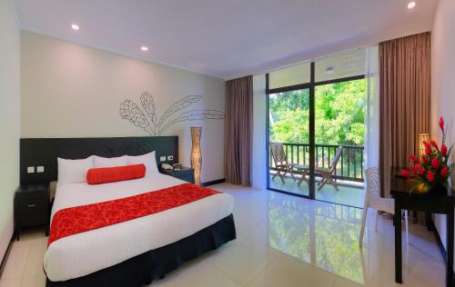 1 dormitorio con 1 cama grande y balcón en Tanoa International Hotel, en Nadi
