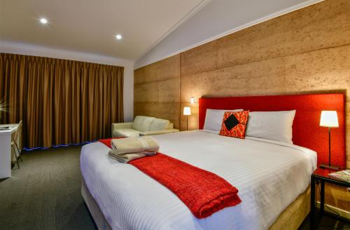 a bedroom with a large bed with a red headboard at Crossroads Ecomotel in Port Augusta