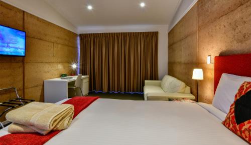 a hotel room with a bed and a desk at Crossroads Ecomotel in Port Augusta